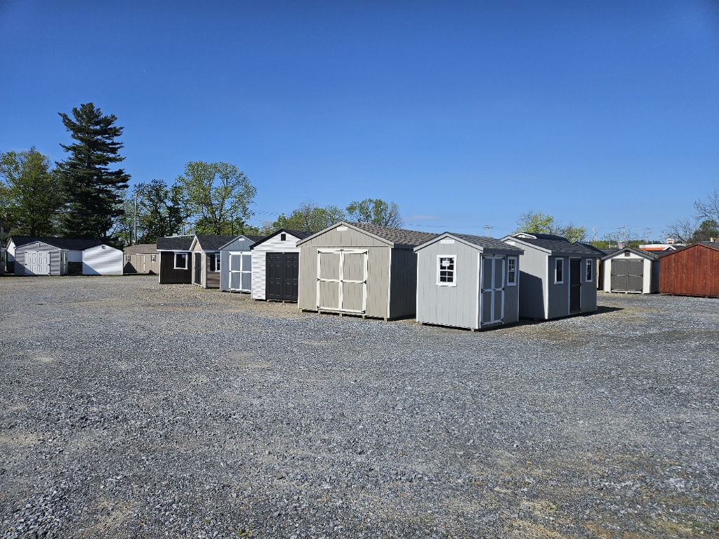 Wide panorama of rows of A-frame sheds and utility buildings in neutral earth tones on the White Pine Structures sales lot